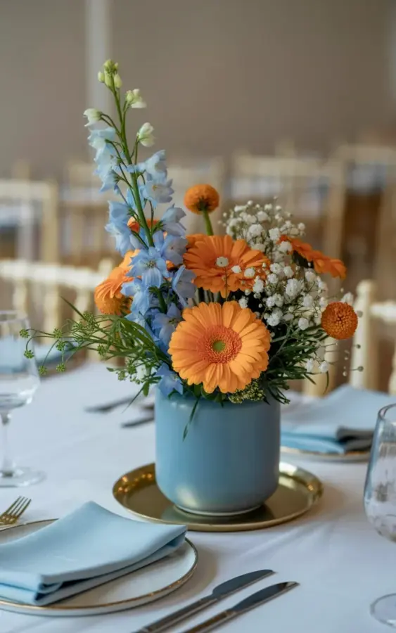 Dusty blue vase with orange gerbera daisies - a stunning floral centerpiece idea