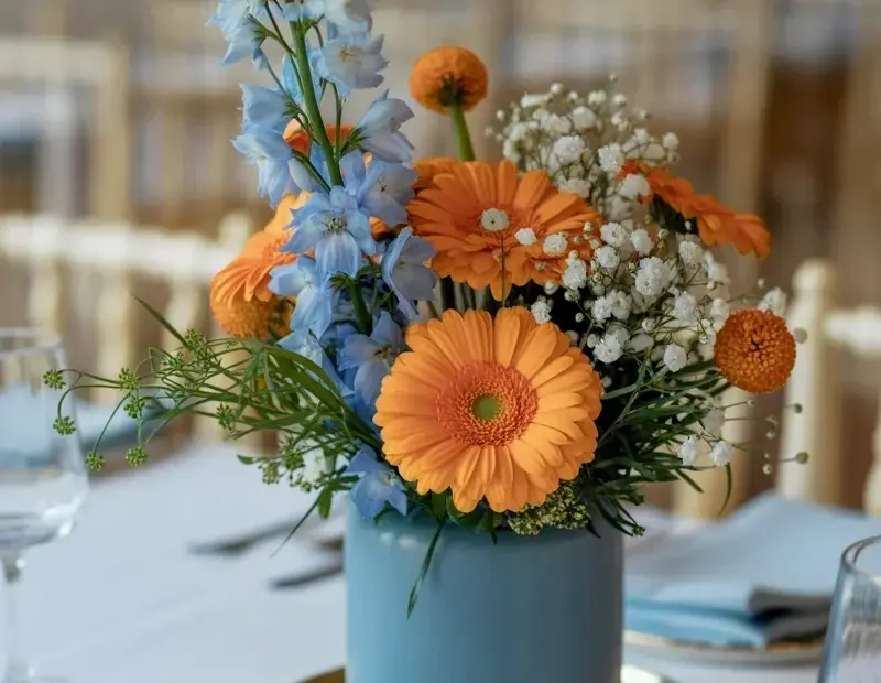 Dusty blue vase with orange gerbera daisies - a stunning floral centerpiece idea